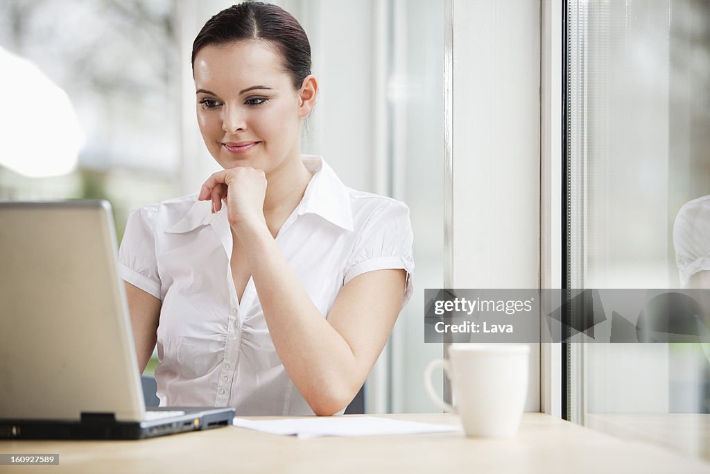 Portrait of young businesswoman working with laptop computer