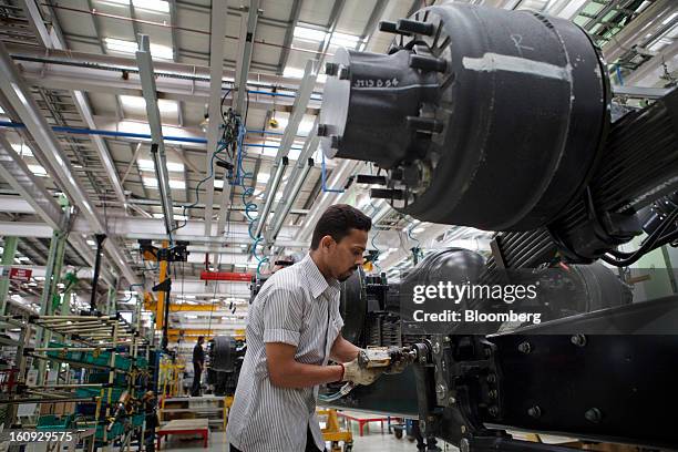 An employee works on a chassis on the assembly line for the Mahindra & Mahindra Ltd. Navistar truck at the company's factory in Chakan, Maharashtra,...