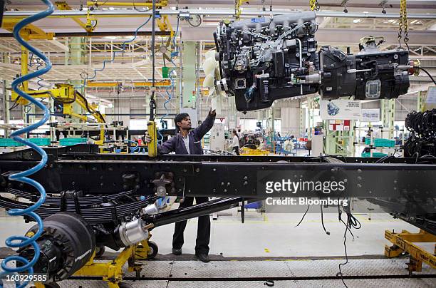 An employee lowers an engine onto a chassis on the assembly line for the Mahindra & Mahindra Ltd. Navistar truck at the company's factory in Chakan,...