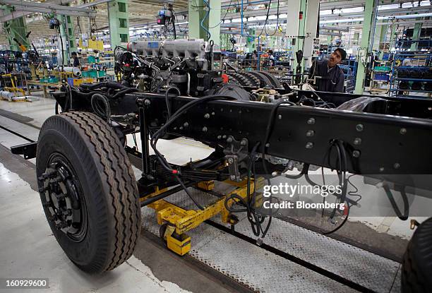 An employee assembles a chassis on the assembly line for the Mahindra & Mahindra Ltd. Navistar truck at the company's factory in Chakan, Maharashtra,...