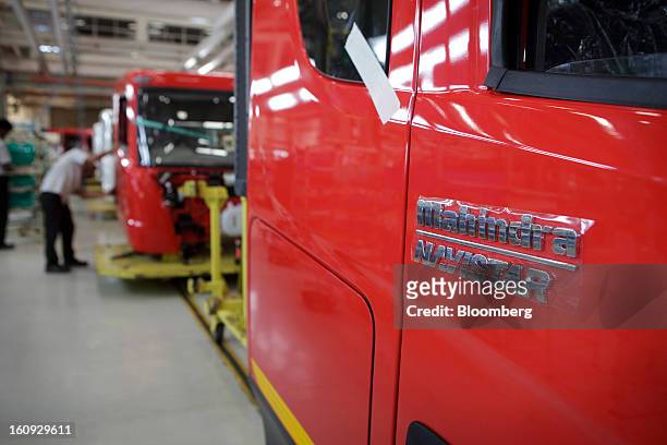 The Mahindra & Mahindra Ltd. Navistar truck emblem badge is adhered to the side of a truck on the assembly line at the company's factory in Chakan,...