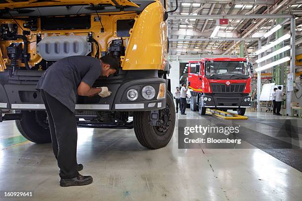 Employees inspect vehicle parts on the assembly line for the Mahindra & Mahindra Ltd. Navistar truck at the company's factory in Chakan, Maharashtra,...