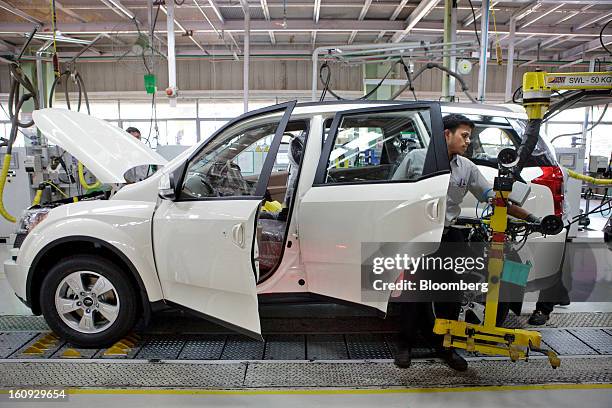 Am employee works on the assembly line for the Mahindra & Mahindra Ltd. XUV 500 sport utility vehicle at the company's factory in Chakan,...