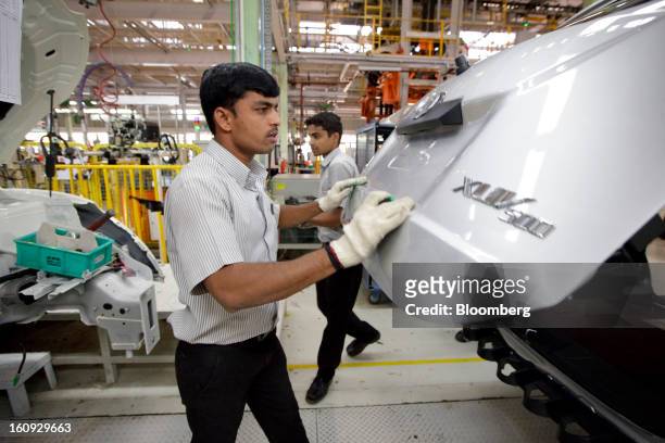 Employees work on the assembly line for the Mahindra & Mahindra Ltd. XUV 500 sport utility vehicle at the company's factory in Chakan, Maharashtra,...