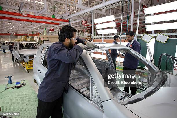 Workers inspect vehicle parts on the assembly line for the Mahindra & Mahindra Ltd. Rexton sport utility vehicle at the company's factory in Chakan,...