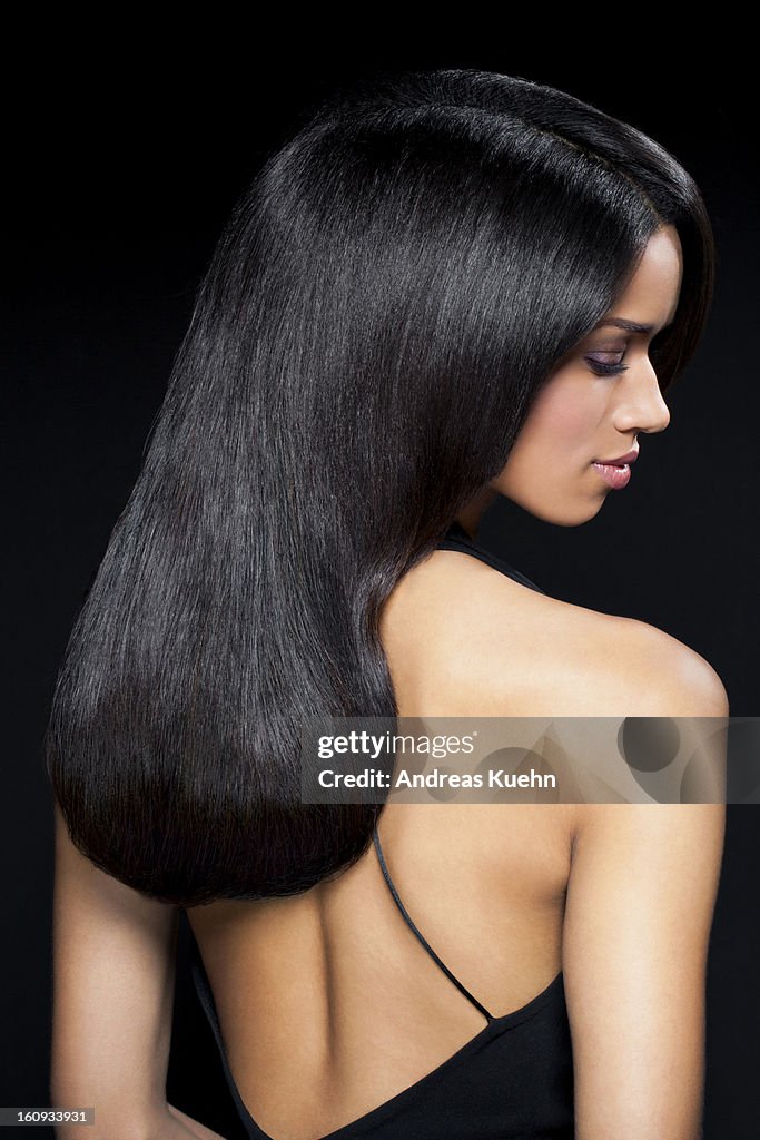 Young woman in black backless dress, profile.