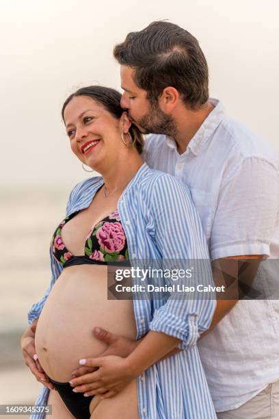 couple hands framing a pregnant wife belly - mujer playa stock pictures, royalty-free photos & images