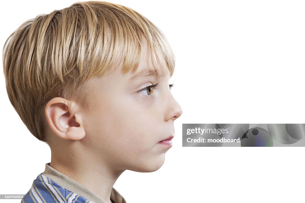 Close-up of young boy looking at copy space over white background