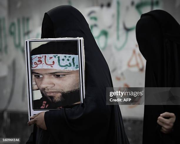 Bahraini woman carries a portrait of jailed activist Hassan Mohammed Hassan during an anti-government rally to demand reforms on February 7, 2013 in...