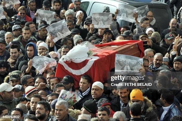 People carry the coffin of late opposition leader Chokri Belaid during his funeral procession which makes its way to the nearby cemetery of El-Jellaz...