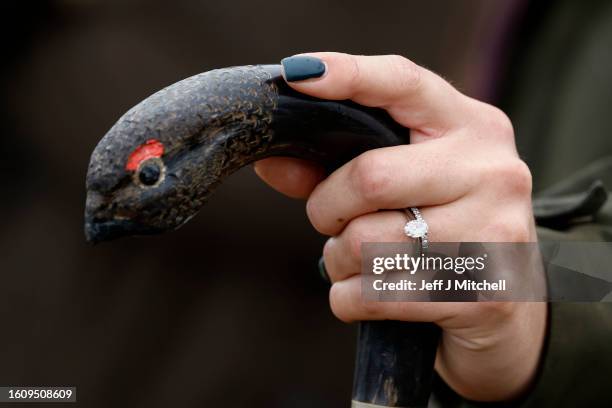Member of a shooting party holds walking stick with a bird's head on the top as they mark the Glorious Twelfth, the annual start of the grouse...