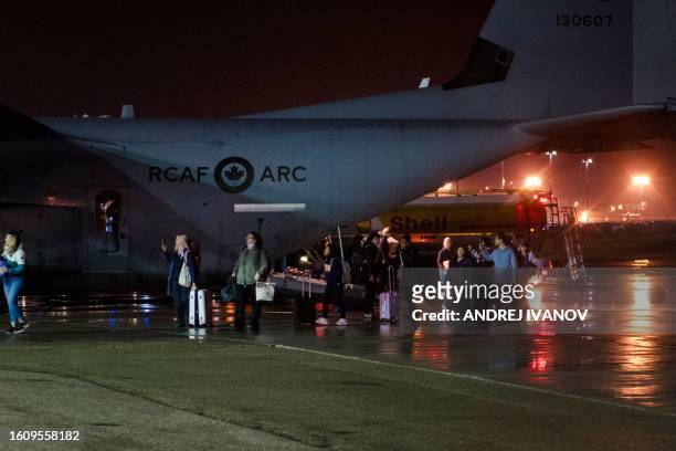 Some of the last people to evacuate Yellowknife step off a Canadian military C-130 Hercules aircraft, August 19 at Edmonton International Airport,...