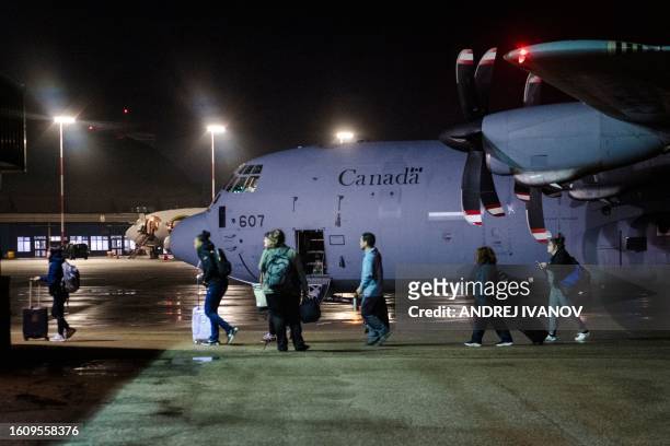 Some of the last people to evacuate Yellowknife step off a Canadian military C-130 Hercules aircraft, August 19 at Edmonton International Airport,...