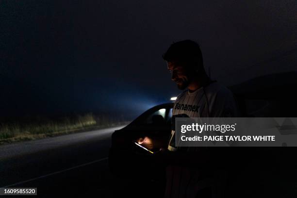 David Cooper calls a friend to help him out on the side of Highway 3 in British Columbia near Rock Creek, where his car broke down during a...