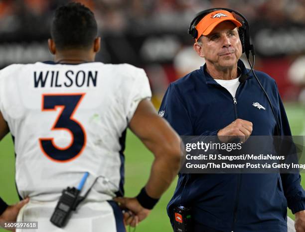 Denver Broncos quarterback Russell Wilson and Head Coach Sean Payton walks passed each other on the sideline during a preseason game at State Farm...