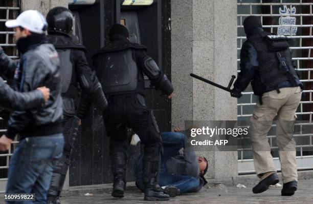 Tunisian policemen beat up a protester during a demonstration following the funeral of assassinated opposition leader Chokri Belaid on Habib...