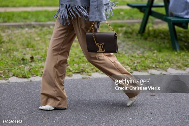 Guest wears Louis Vuitton bag in brown outside Helmstedt during the Copenhagen Fashion Week Spring/Summer 2024 on August 10, 2023 in Copenhagen,...