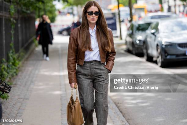 Annabel Rosendahl wears brown leather jacket, grey pants, bag outside Mark Kenly Domino Tan during the Copenhagen Fashion Week Spring/Summer 2024 on...