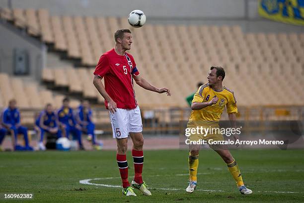Brede Hangeland of Norway controls the ball as Oleh Husyev of Ukraine looks on during the international friendly football match between Norway and...