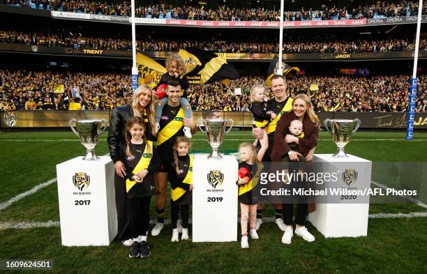 Jack Riewoldt of the Tigers and Trent Cotchin of the Tigers pose with the premiership cups with their wives and children after tier final matches...