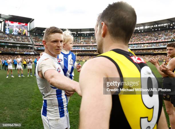 Jack Ziebell of the Kangaroos and Trent Cotchin of the Tigers embrace after their final matches during the 2023 AFL Round 23 match between the...