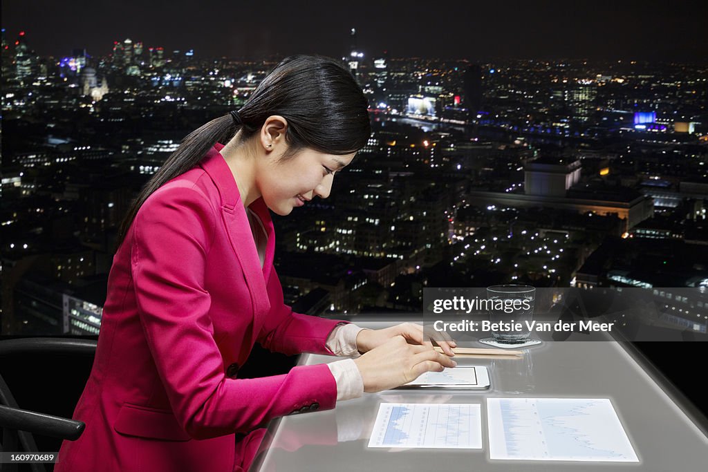 Woman working on i-pad and interactive table