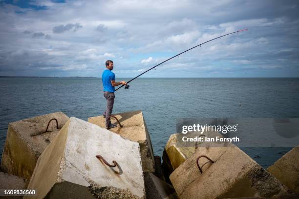 Fisherman fishes for Mackerel from the breakwater at South Gare on August 12, 2023 in Redcar, United Kingdom.