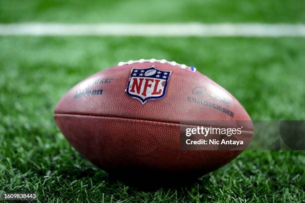 The NFL logo is pictured on a Wilson brand football before the preseason game between the Detroit Lions and New York Giants at Ford Field on August...