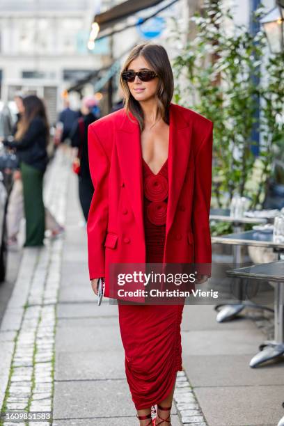 Darja Barannik wears red oversized blazer, dress, heeled sandals outside Rotate during the Copenhagen Fashion Week Spring/Summer 2024 on August 10,...