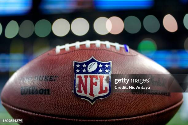 The NFL logo is pictured on a Wilson brand football before the preseason game between the Detroit Lions and New York Giants at Ford Field on August...