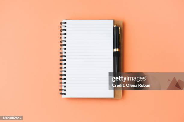 black pen lying on open notepad. - carnet à spirale photos et images de collection