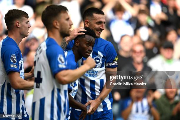 Simon Adingra of Brighton & Hove Albion celebrates with teammate Lewis Dunk after scoring the team's third goal during the Premier League match...