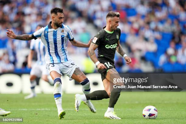 Brais Mendez of Real Sociedad battles for possession with Aleix Garcia of Girona during the LaLiga EA Sports match between Real Sociedad and Girona...