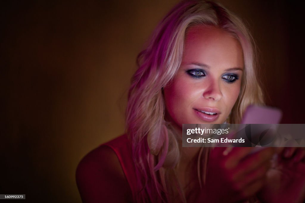 Close up of woman checking cell phone in dark