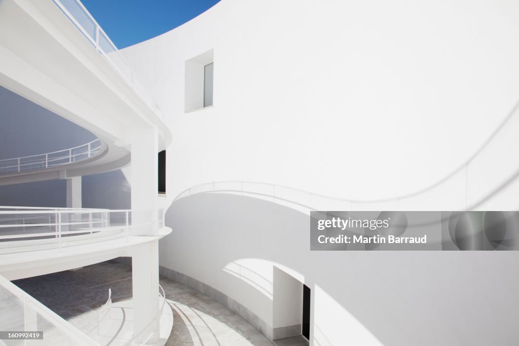 Shadow of curving elevated walkway on sunny wall