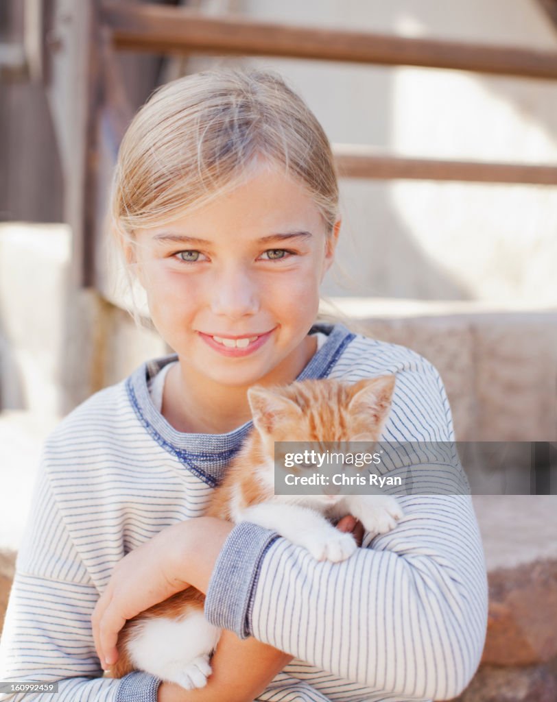 Portrait of smiling girl holding kitten