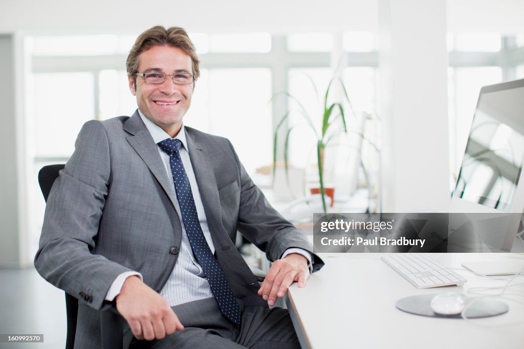 Portrait of smiling businessman at desk