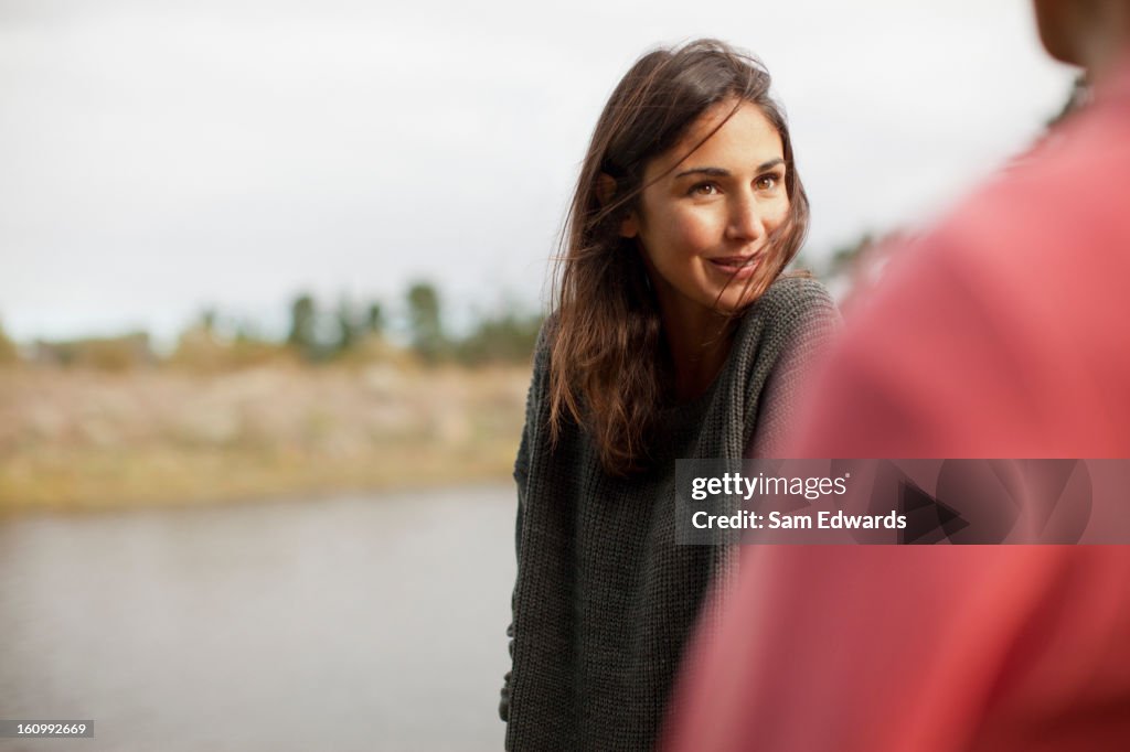 Smiling woman looking at man at lakeside