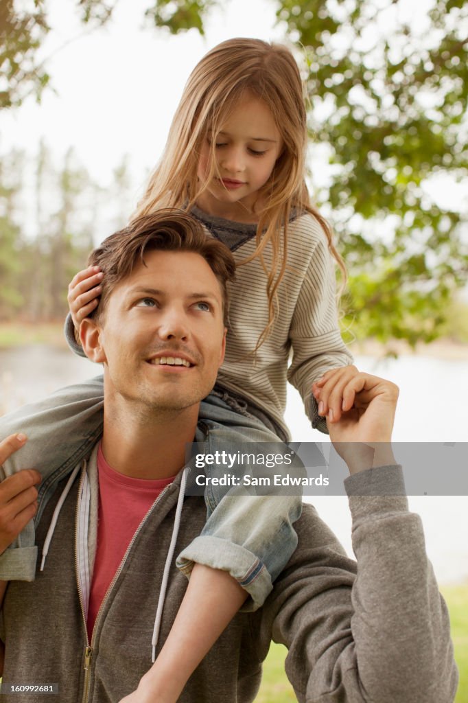 Hija de padre llevar en hombros en lakeside