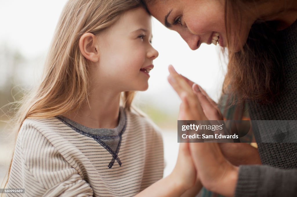 Close up of mother and daughter holding hands