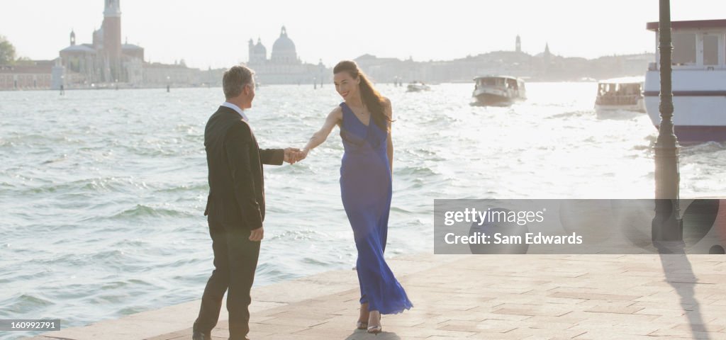 Well-dressed man and woman at waterfront in Venice