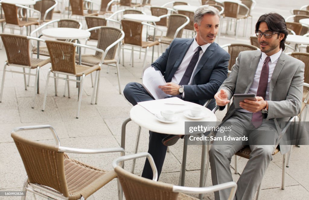 Businessmen meeting at sidewalk cafe