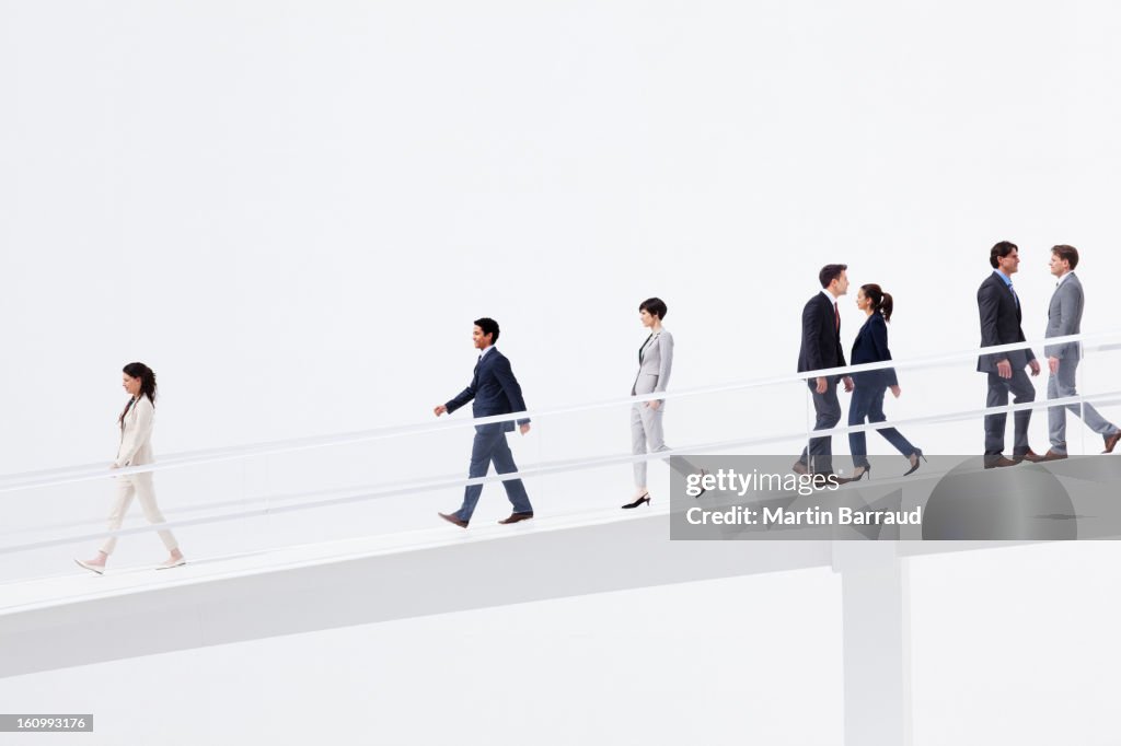 Business people walking down elevated walkway