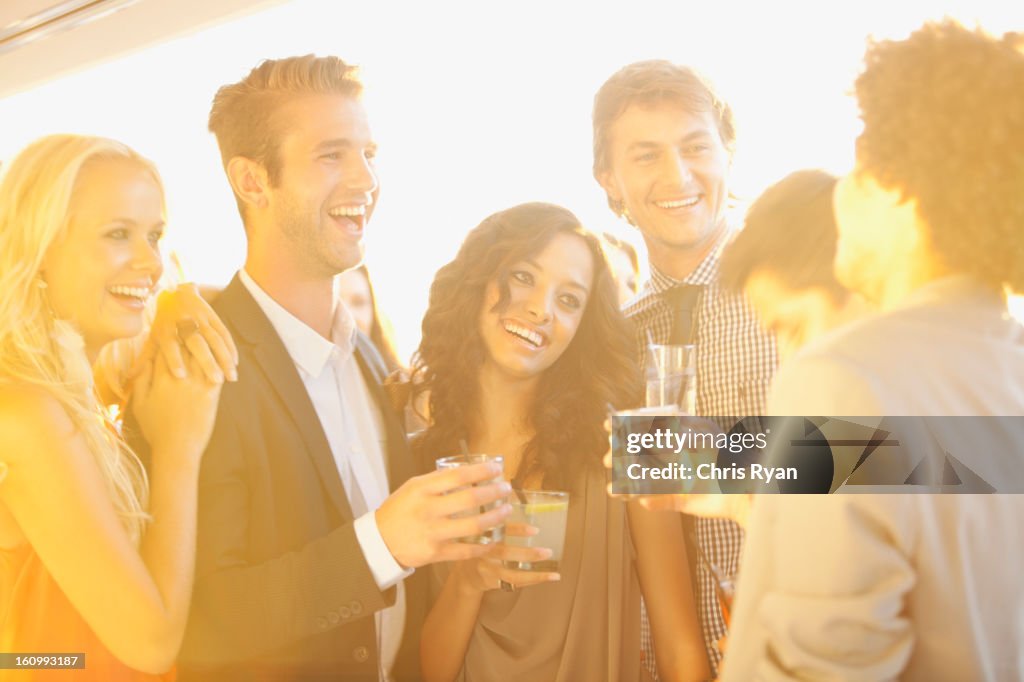 Lächelnd Freunde trinken cocktails am sonnigen Balkon