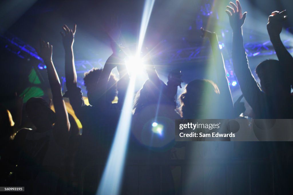 Spotlight over crowd dancing on dance floor