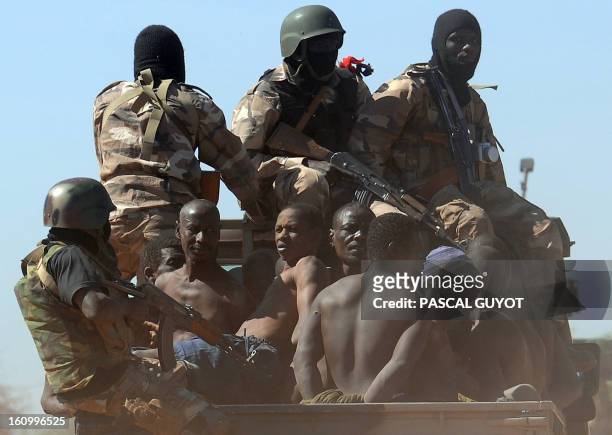 Malian soldiers transport in a pickup truck a dozen suspected Islamist rebels on February 8, 2013 after arresting them north of Gao. A suicide bomber...