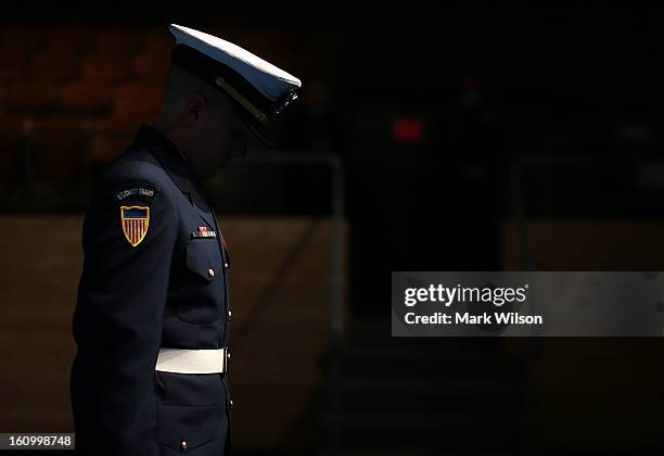 Member of the U.S. Coast Guard honor guard team stands in the shadows during a armed services farewell ceremony for Sec. Panetta at Joint Base Ft....