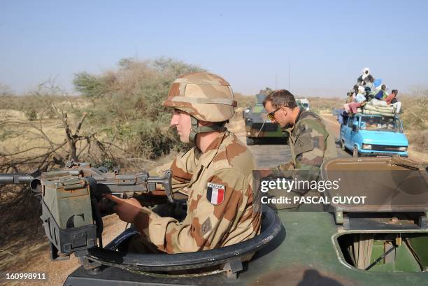 Local truck drives by a convoy of French army vehicules heading toward Gao on February 7, 2013 on the road from Gossi. Four Malian civilians were...