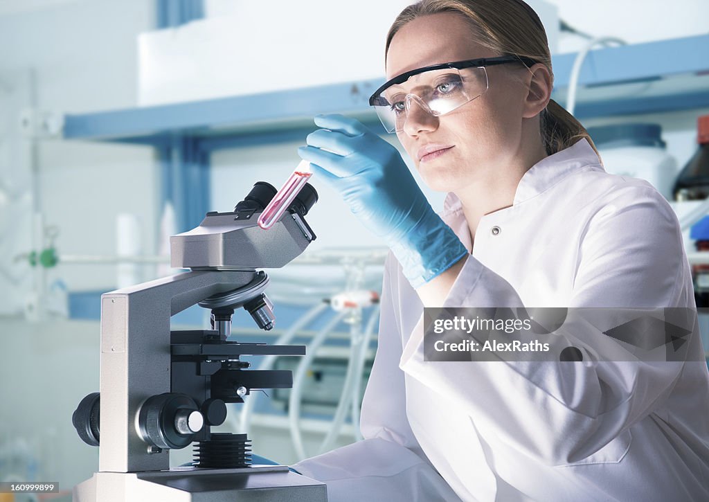 Female laboratory technician holding test tube