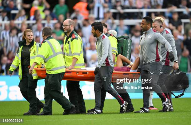 Tyrone Mings of Aston Villa leaves the field on a stretcher after sustaining an injury during the Premier League match between Newcastle United and...